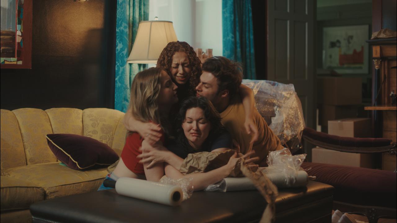 The four in an emotional group hug amid moving boxes