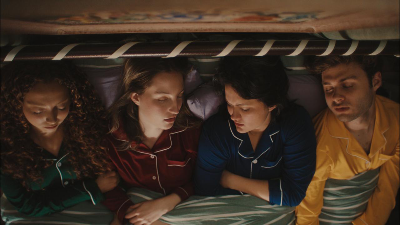The four asleep side by side in one bed
