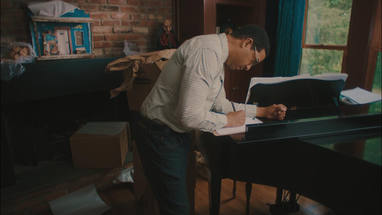 Craig bent over the piano, writing
